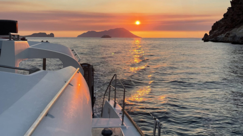 Capture the golden light reflecting off dramatic cliffs and turquoise waters