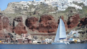 Gaze at the rugged beauty of Santorini’s cliffs as the catamaran sails by