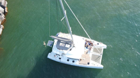 Let the stillness envelop you as the catamaran anchors