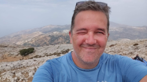 Ένας πεζοπόρος στην κορυφή του βουνού, χαρούμενος με το κατόρθωμά του