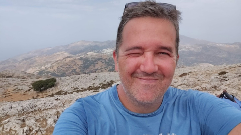 Ένας πεζοπόρος στην κορυφή του βουνού, χαρούμενος με το κατόρθωμά του