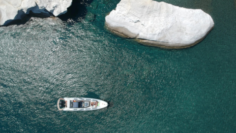 Capture the contrast of white rock formations against deep blue seas