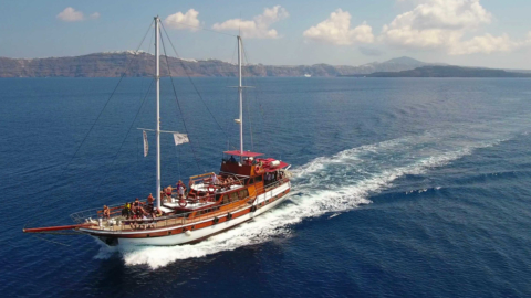Embark on a timeless journey across Santorini’s waters on a wooden boat