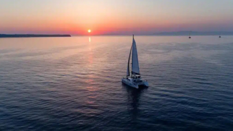 Sail into the heart of Santorini’s volcanic beauty at golden hour
