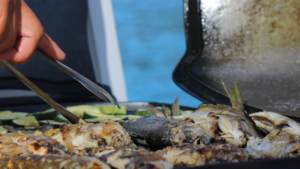 Taste freshly grilled catch prepared onboard during sunset