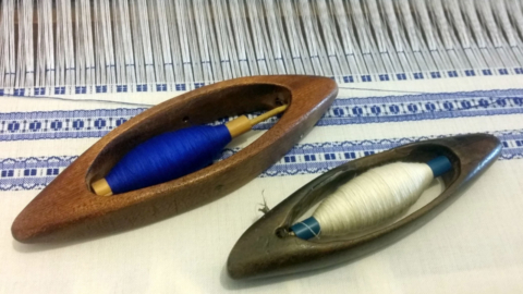 The shuttles that move the weft between the threads