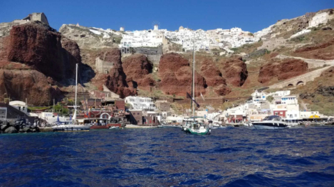 Arrive by sea to asSecluded port carved into red cliffs