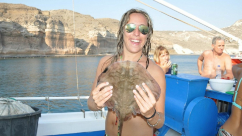 Pose proudly with your catch against the backdrop of the Aegean