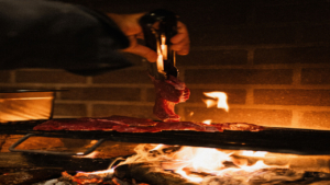 Watch the outdoor kitchen come alive by the fire